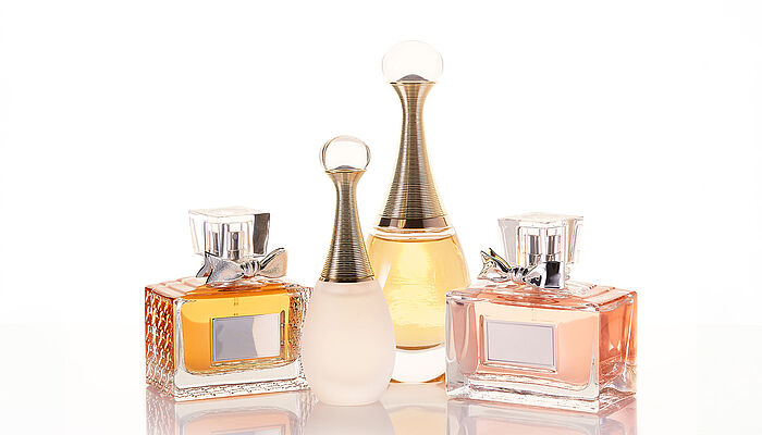 A collection of elegant perfume bottles arranged aesthetically on a reflective surface, highlighting luxury and personal style.