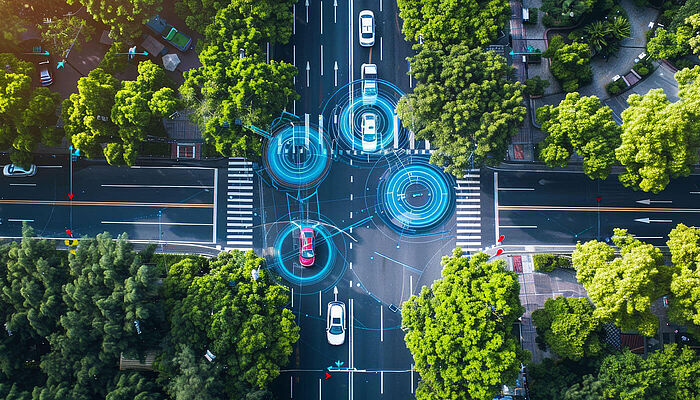 Aerial view of autonomous vehicles moving through a city intersection, overlaid with digital graphics indicating advanced navigation technology and connectivity