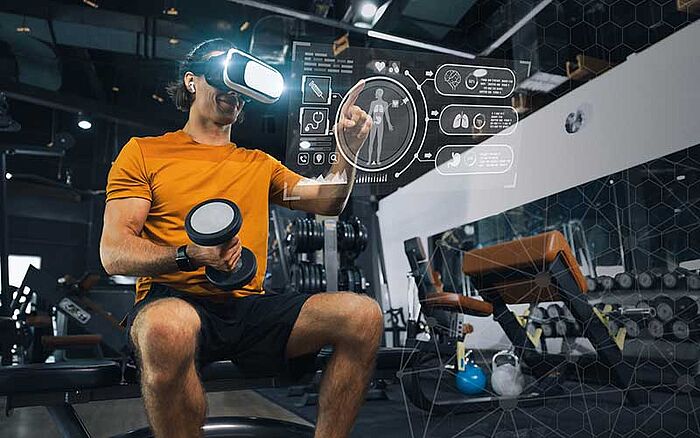 A man in a modern gym using augmented reality technology to track his progress.