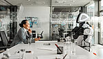 Side view of a smiling Asian businesswoman engaging in a conversation with a robot in a modern conference hall, emphasizing a professional and futuristic atmosphere.
