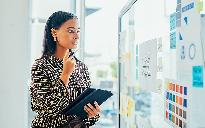Woman reviewing sticky notes to review her trademark filing strategy. 
