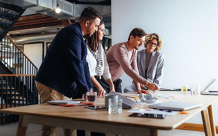 Team of professionals gathered around a table, actively discussing business ideas.