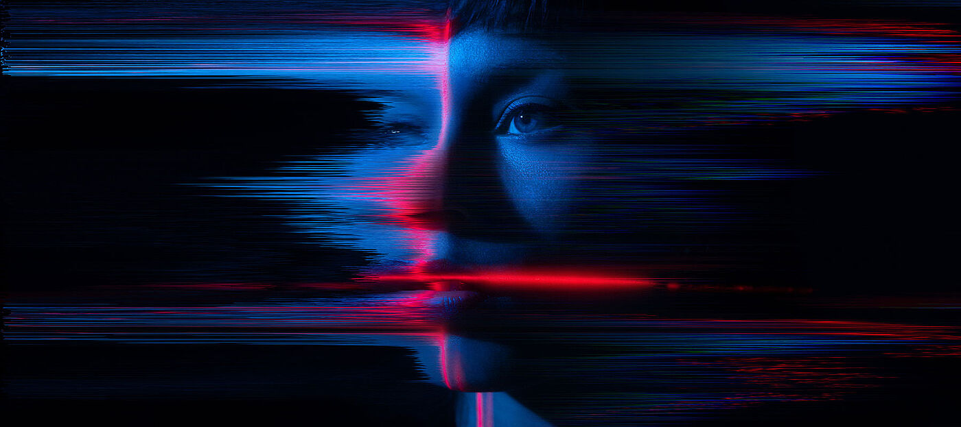 Close-up of a young woman's face appearing to glitch and fragment digitally, representing the loss and replacement of identity.