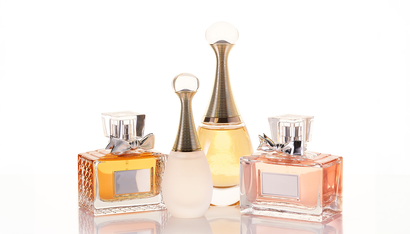A collection of elegant perfume bottles arranged aesthetically on a reflective surface, highlighting luxury and personal style.